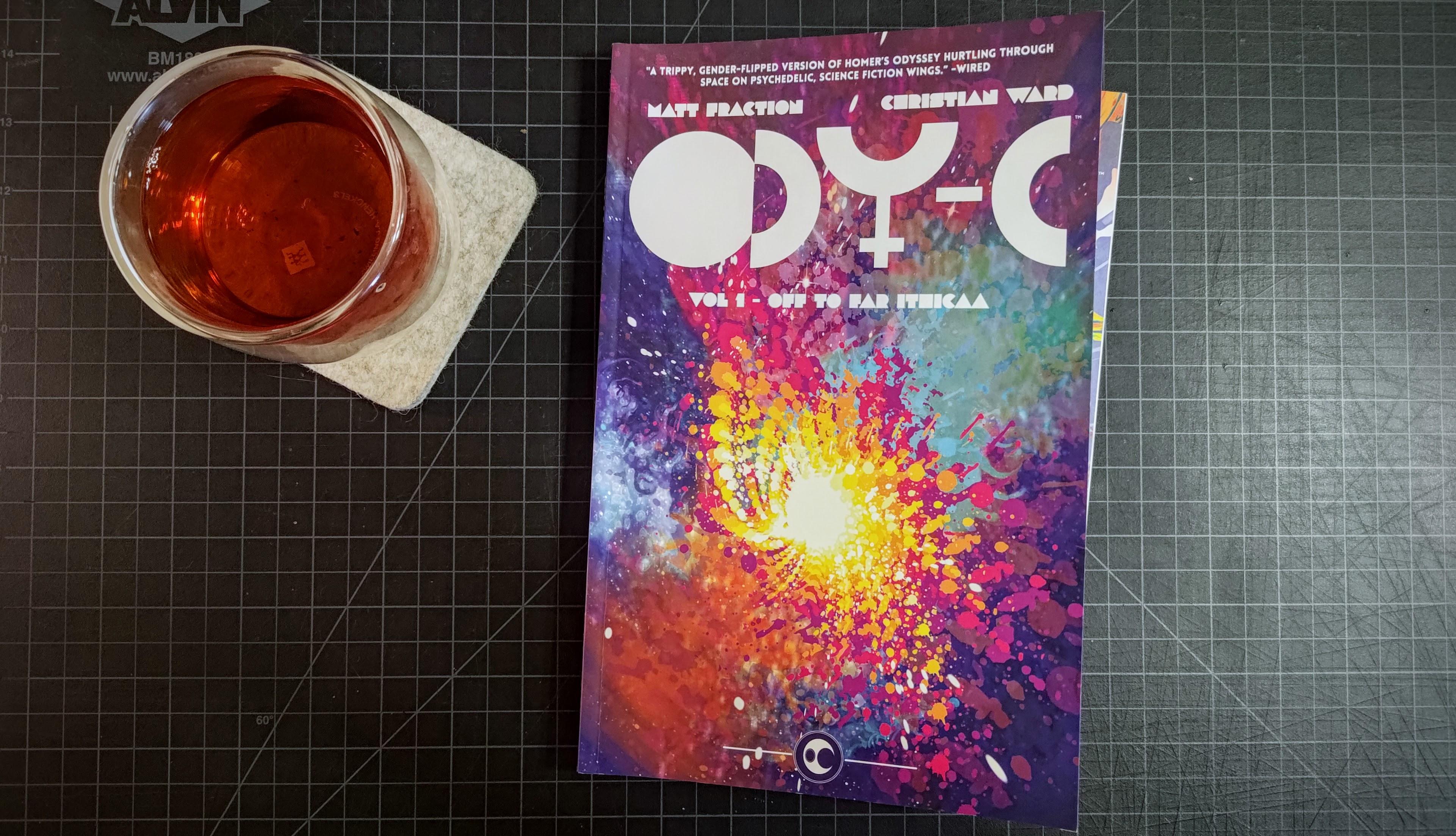 Volume 1 of the ODY-C comic series with its psychedelic cover, alongside a glass of tea